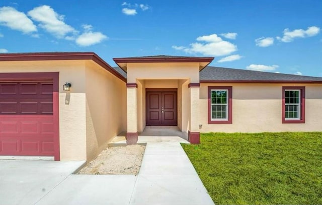 doorway to property with a lawn and a garage