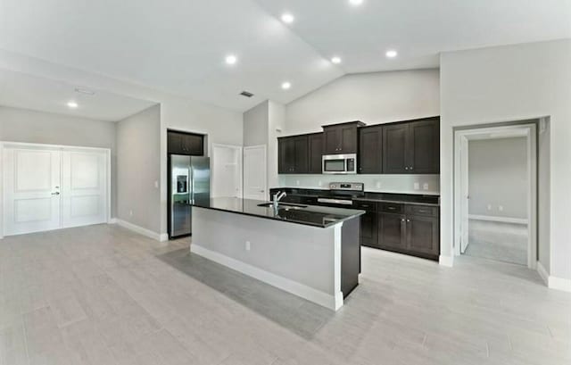 kitchen with high vaulted ceiling, sink, an island with sink, dark brown cabinets, and stainless steel appliances