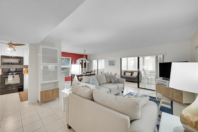 tiled living room with ceiling fan and a textured ceiling