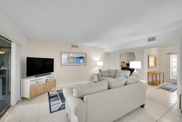 tiled living room featuring a textured ceiling