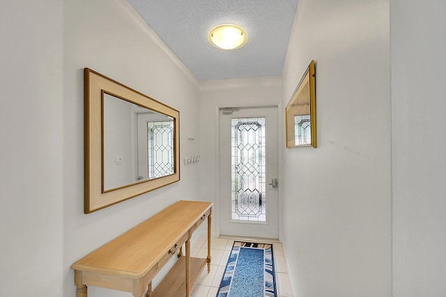 doorway to outside with light tile patterned floors and a textured ceiling