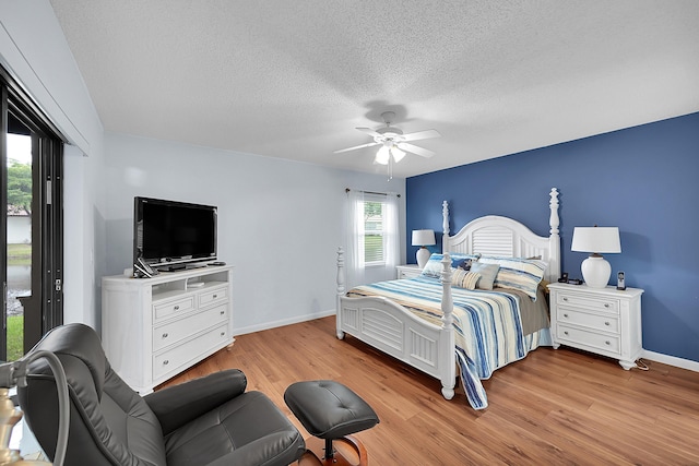 bedroom featuring ceiling fan, a textured ceiling, and light wood-type flooring