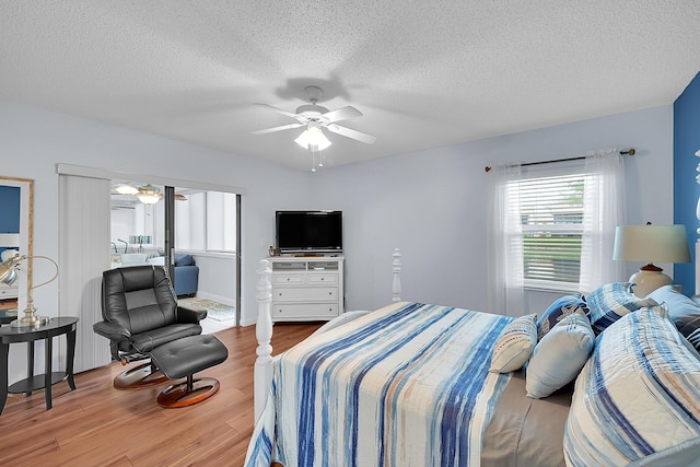 bedroom with wood-type flooring, ceiling fan, and a textured ceiling