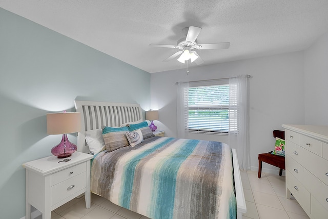 tiled bedroom featuring ceiling fan and a textured ceiling