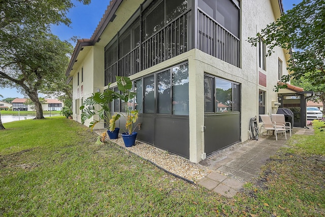 view of side of home with a water view and a lawn