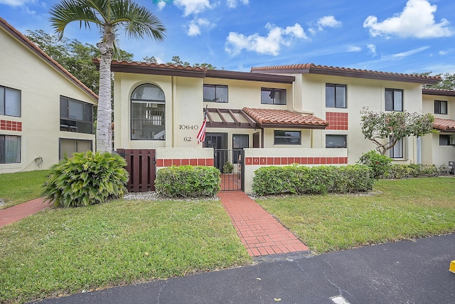 mediterranean / spanish-style house with a front yard