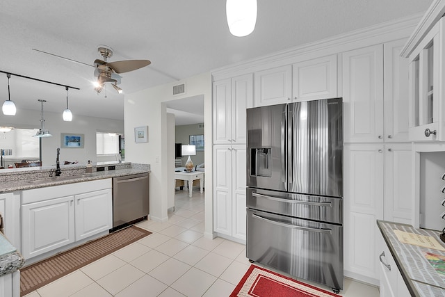 kitchen featuring sink, light tile patterned floors, stainless steel appliances, and white cabinets