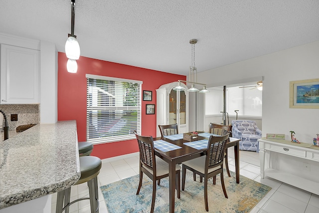 dining room featuring light tile patterned floors and a textured ceiling