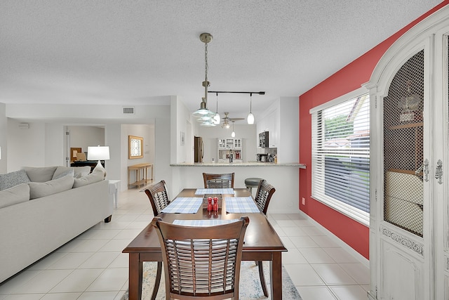 tiled dining space with a textured ceiling