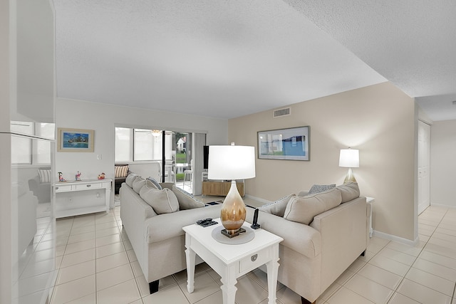 living room with a textured ceiling and light tile patterned floors