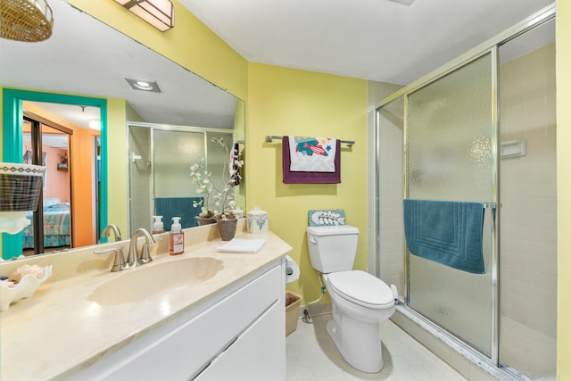 bathroom with tile patterned floors, vanity, an enclosed shower, and toilet