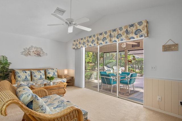 carpeted living room with ceiling fan and vaulted ceiling