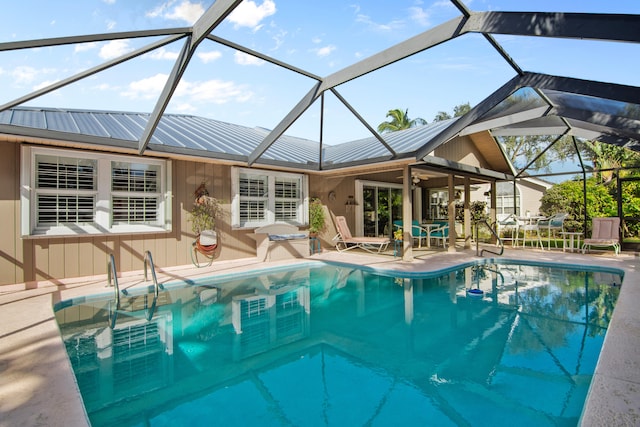 view of swimming pool featuring glass enclosure and a patio area