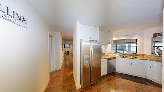 kitchen with white cabinets, appliances with stainless steel finishes, dark hardwood / wood-style floors, and sink