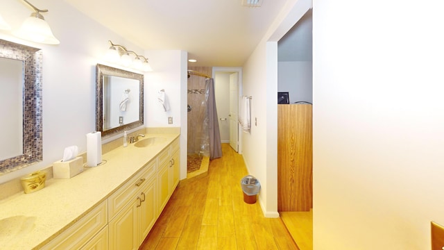 bathroom with hardwood / wood-style floors, vanity, and walk in shower