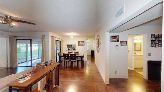 corridor featuring dark hardwood / wood-style flooring and a textured ceiling