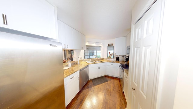 kitchen featuring dark wood-type flooring, white cabinets, stainless steel appliances, and sink