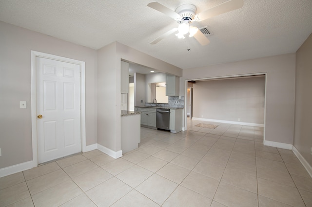 tiled spare room featuring sink, a textured ceiling, and ceiling fan