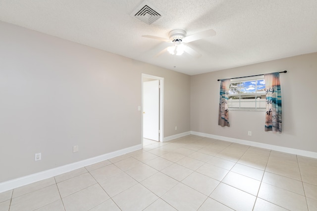 tiled spare room featuring a textured ceiling and ceiling fan