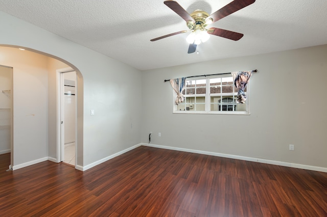 spare room with ceiling fan, a textured ceiling, and dark hardwood / wood-style flooring