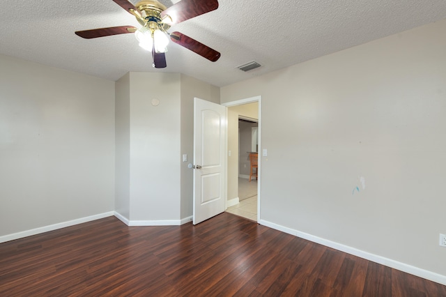 spare room with dark hardwood / wood-style floors and a textured ceiling