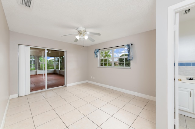 unfurnished room featuring light tile patterned floors, a textured ceiling, and ceiling fan