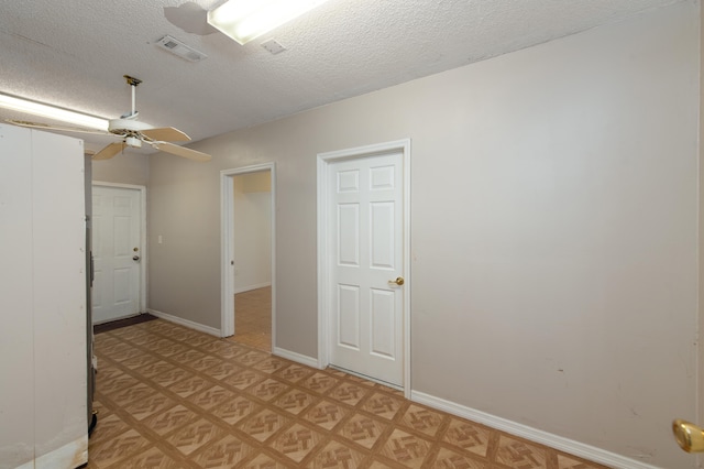 spare room featuring a textured ceiling, light parquet floors, and ceiling fan