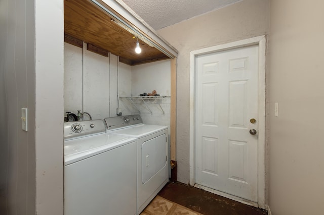 washroom featuring parquet floors, independent washer and dryer, and a textured ceiling