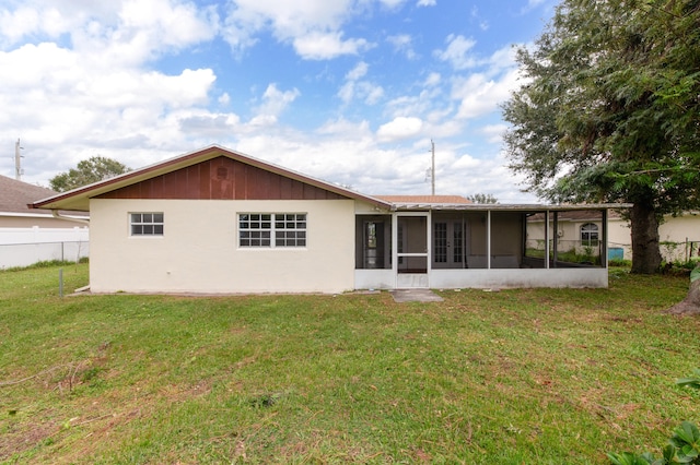 rear view of house with a yard and a sunroom