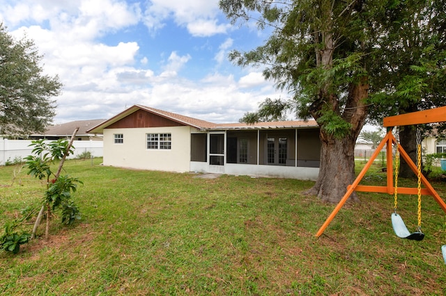 back of house with a sunroom and a yard