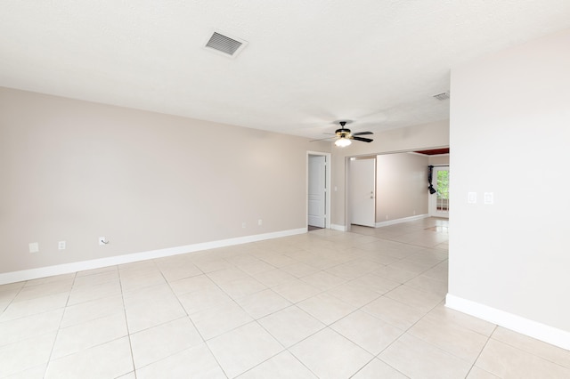 tiled empty room featuring a textured ceiling and ceiling fan