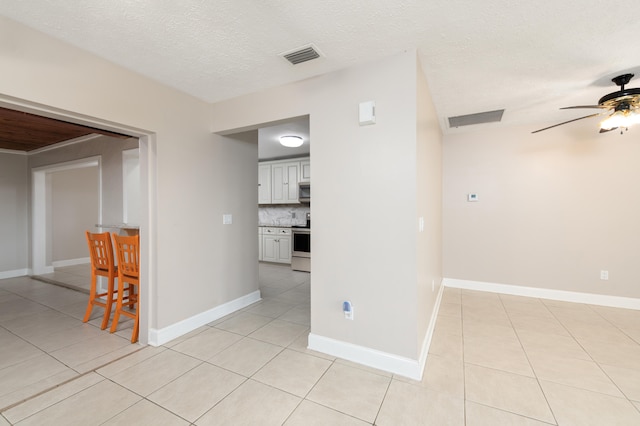 unfurnished room featuring light tile patterned floors, a textured ceiling, and ceiling fan