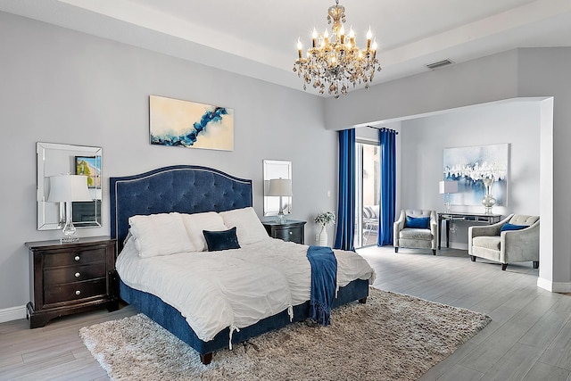 bedroom with a chandelier and light hardwood / wood-style floors