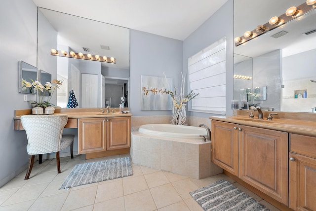 bathroom with tile patterned flooring, vanity, and tiled bath