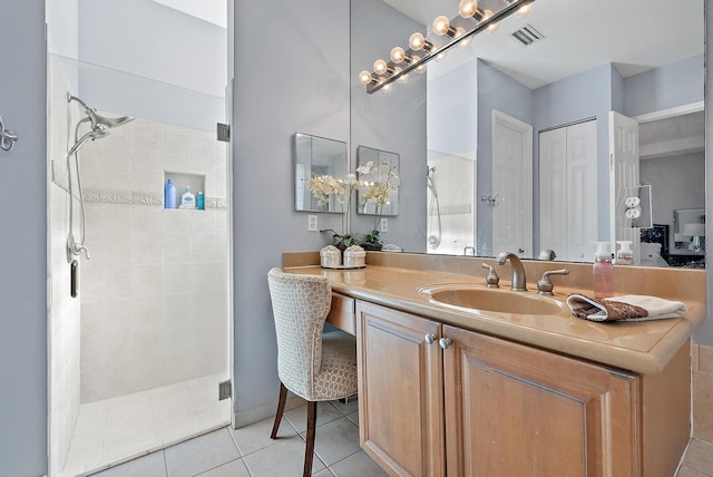 bathroom featuring tile patterned floors, a shower with door, and vanity