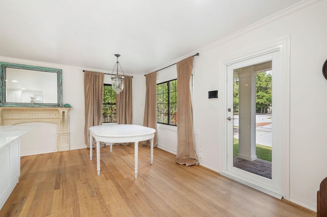 dining room featuring light wood-type flooring, ornamental molding, and an inviting chandelier