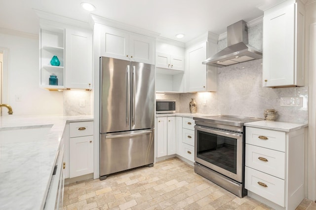 kitchen featuring white cabinets, light stone countertops, wall chimney range hood, and stainless steel appliances