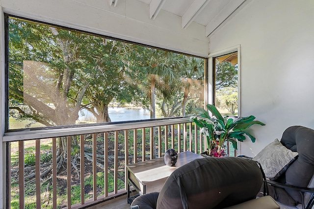 sunroom / solarium with vaulted ceiling with beams and a water view