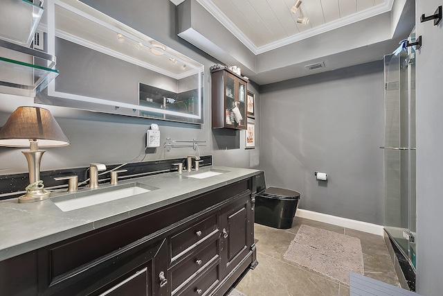 bathroom featuring vanity, a tray ceiling, toilet, and ornamental molding