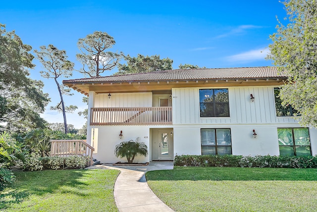 view of front of house featuring a front yard and a balcony