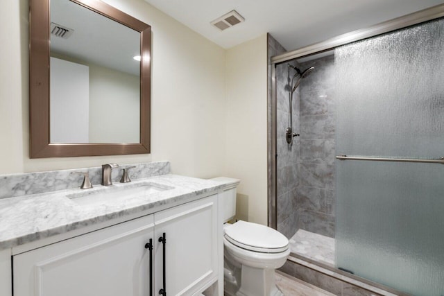 bathroom with vanity, an enclosed shower, and toilet