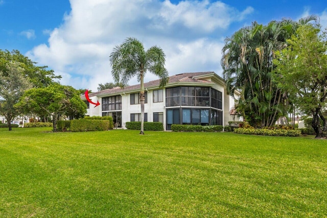 back of property featuring a sunroom and a yard