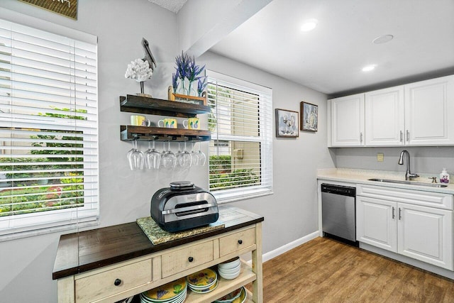 kitchen with white cabinets, dishwasher, a healthy amount of sunlight, and light hardwood / wood-style floors