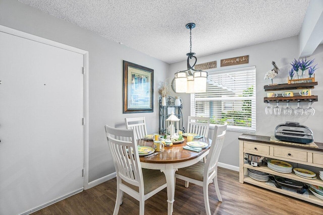 dining area with hardwood / wood-style floors and a textured ceiling