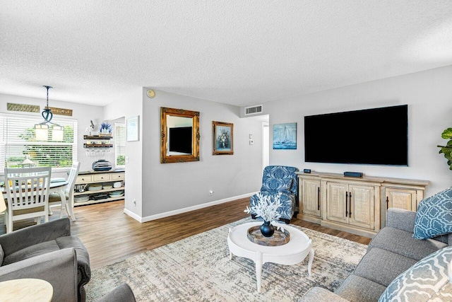 living room with light wood-type flooring and a textured ceiling