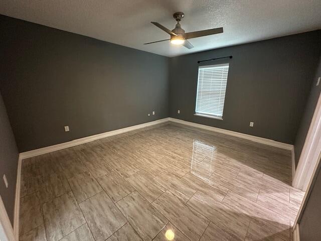 spare room with a textured ceiling and ceiling fan