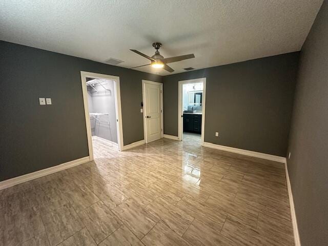 unfurnished room featuring ceiling fan and a textured ceiling