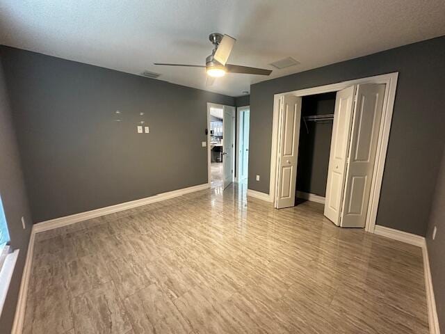 unfurnished bedroom with ceiling fan, a closet, a textured ceiling, and hardwood / wood-style flooring