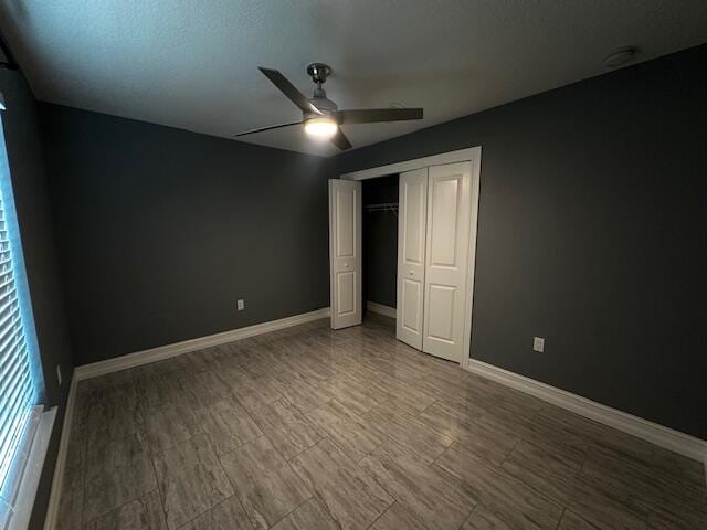 unfurnished bedroom with ceiling fan, a textured ceiling, and a closet