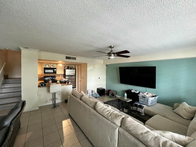 tiled living room featuring ceiling fan, crown molding, and a textured ceiling